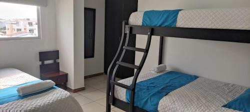two bunk beds in a room with a ladder at Hotel Mykonos Manta in Manta