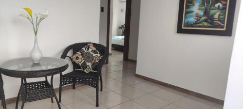 een tafel en een stoel met een vaas erop bij Hotel Mykonos Manta in Manta