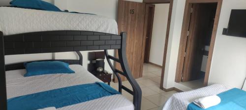 曼塔的住宿－Hotel Mykonos Manta，一间卧室配有两张双层床和电视