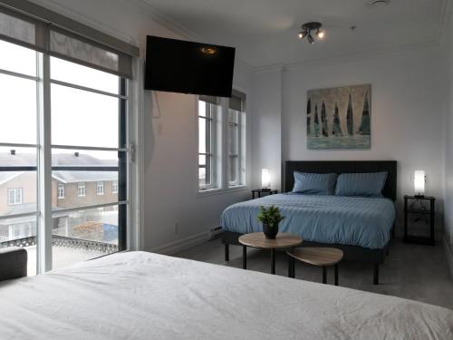 a bedroom with two beds and a table and a window at Modern Loft Chute-Montmorency in Boischâtel