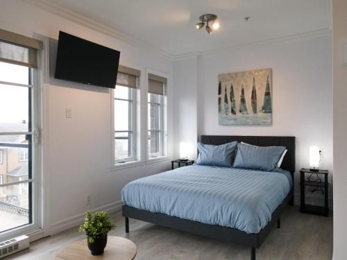 a bedroom with a bed and a flat screen tv at Modern Loft Chute-Montmorency in Boischâtel