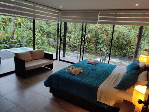 a bedroom with a bed and a large window at Mindo Garden Lodge and Wildlife Reserve in Mindo