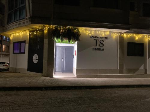 a white building with a door with lights on it at Apartamentos TARELA Porriño in Porriño