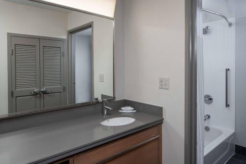a bathroom with a sink and a mirror at Courtyard by Marriott Covington / Mandeville in Covington
