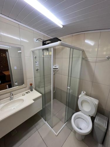 een badkamer met een douche, een toilet en een wastafel bij Pousada Família in Santo Antônio do Pinhal