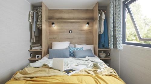 1 dormitorio con 1 cama con ordenador portátil en PARADISE CHALLETS AND CAMPING, en Sarrecave