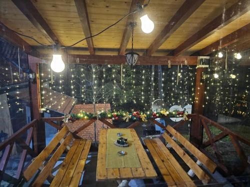 einen Holztisch in einem Zimmer mit Weihnachtsbeleuchtung in der Unterkunft Divcibarski Konak in Divčibare