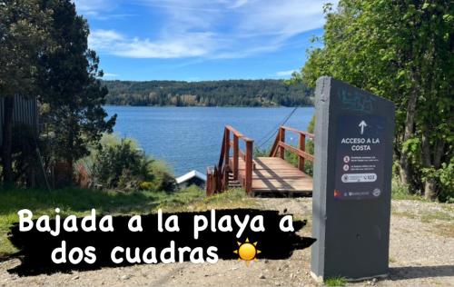 um sinal em frente a um lago com as palavras babako a la playa em Nueva Serena em San Carlos de Bariloche