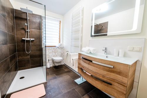 uma casa de banho com um lavatório e um chuveiro em Appartements Flor em Wasserhofen