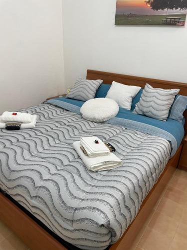 łóżko z niebiesko-białym kocem i poduszkami w obiekcie Sweet Home Sofia w mieście Norma