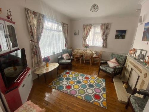 uma sala de estar com uma televisão, um sofá e uma mesa em Sunrise Cottage em Killybegs