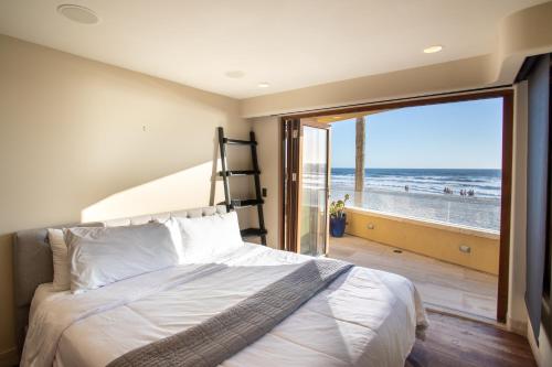 um quarto com uma cama e vista para a praia em Verona Oceanfront Luxury Villa w Spa, Multiple Private Patios, Grill, AC & Garage em San Diego