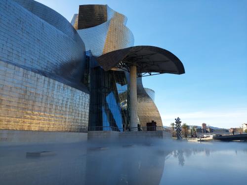 a large glass building with a dome on top of water at bilbao center apt 90´s PARKING in Bilbao