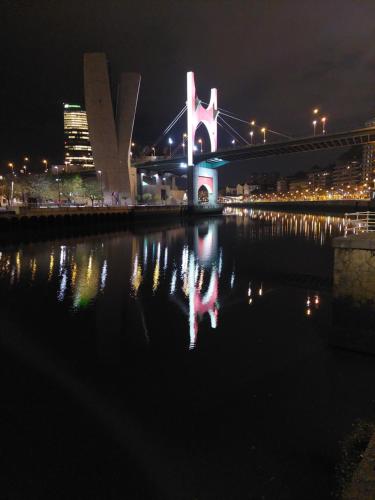 a view of a bridge at night with a city at bilbao center apt 90´s PARKING in Bilbao