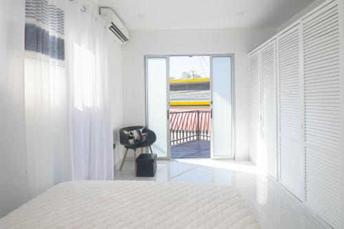 a bedroom with a bed and a window and a chair at Apartamentos Cristal in Quepos