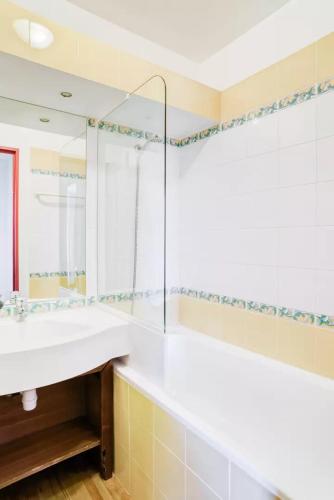 une salle de bain avec un lavabo blanc et une douche dans l'établissement Résidence Le Rami Les Coches - La Plagne, à La Plagne Tarentaise