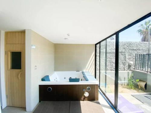 ein Bad mit einer Badewanne und einem großen Fenster in der Unterkunft Departamento 2 espacios, 1 pieza in Santiago