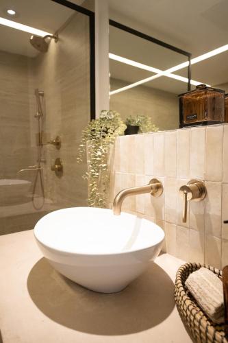 a bathroom with a white bowl sink and a shower at OCEAN VIEW DELUXE SUITE: PVT. BEACH & POOL in San Juan