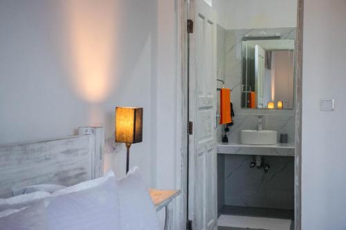 a white bathroom with a sink and a mirror at 4 U Luxury Bungalows Diani in Diani Beach