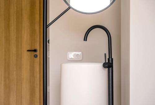 a floor lamp and an umbrella next to a door at Allure Wellness Retreat in Lefkada Town