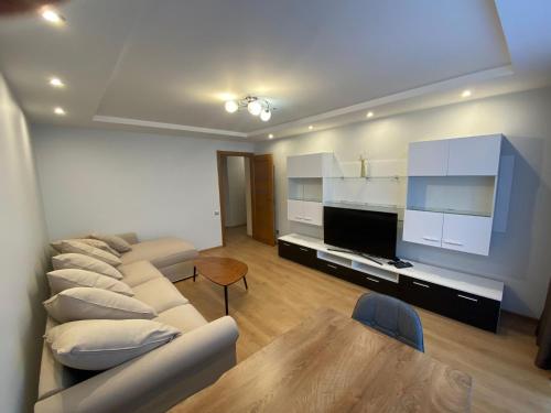 a living room with couches and a tv and a table at Rezekne Cozy Stay in Rēzekne