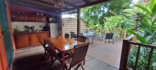 a wooden deck with a table and chairs on it at Les Manguiers in Deshaies