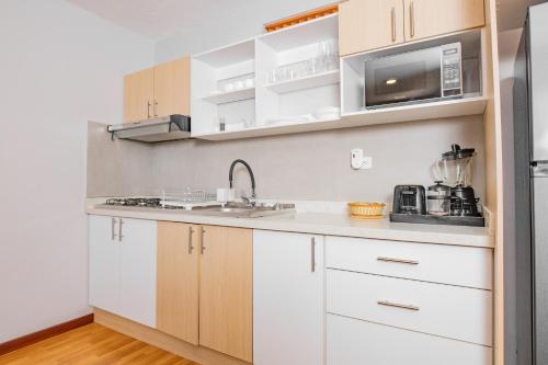 a kitchen with white cabinets and a sink at Santa Lucia Suites - Barranco in Cuenca