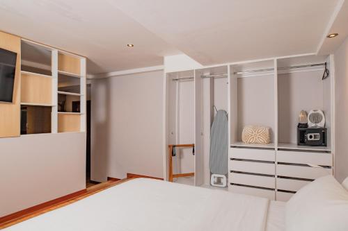 a bedroom with a large white bed and cabinets at Santa Lucia Suites - Barranco in Cuenca