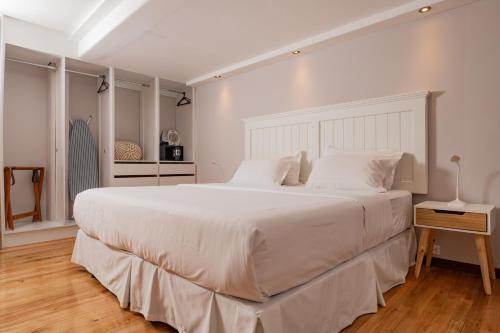 1 dormitorio blanco con 1 cama blanca grande con almohadas blancas en Santa Lucia Suites - Barranco en Cuenca