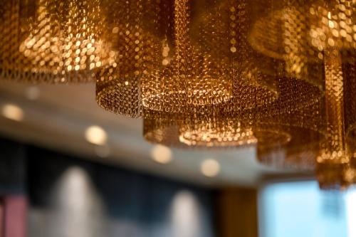 a bunch of gold chandeliers hanging from a ceiling at WITTMANNs in Neumarkt in der Oberpfalz