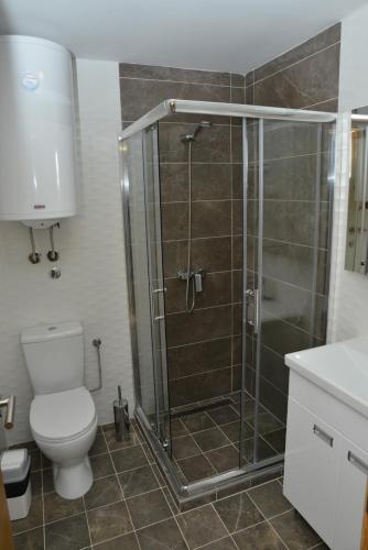 a bathroom with a toilet and a glass shower at Kraljevi Cardaci Cardak in Kopaonik