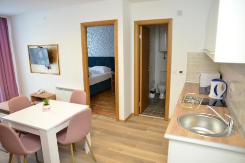 eine Küche mit einem Waschbecken und ein Zimmer mit einem Bett in der Unterkunft Kraljevi Cardaci Cardak in Kopaonik