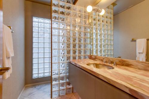 a bathroom with a sink and a glass wall at Mission Bay Dreams - w Bay Access, Parking, Pool & Spa in San Diego