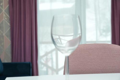 a wine glass sitting on a table next to a window at Kraljevi Cardaci Cardak in Kopaonik