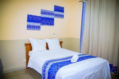 - une chambre dotée d'un lit avec des draps bleus et blancs dans l'établissement Dreams House, à Libreville