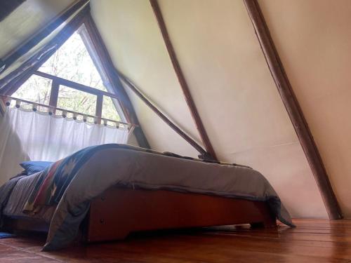 a bed in a room with a window at The lookout Hideaway cabin in Baños