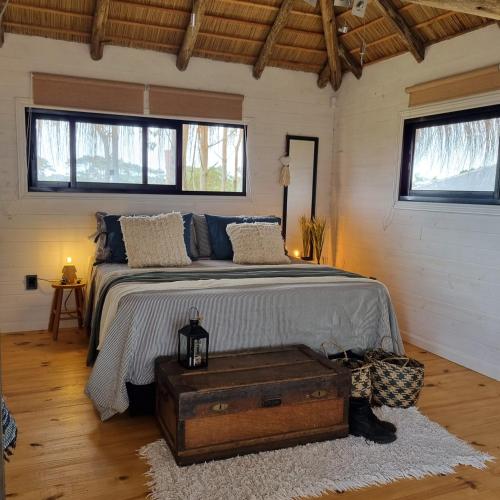 a bedroom with a large bed with a wooden floor at Juanillo's ll in Punta Del Diablo