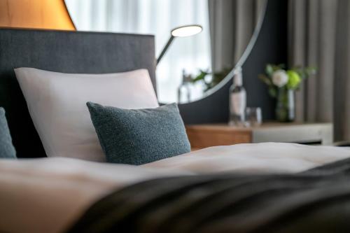 a bed with two pillows and a table with a lamp at WITTMANNs in Neumarkt in der Oberpfalz