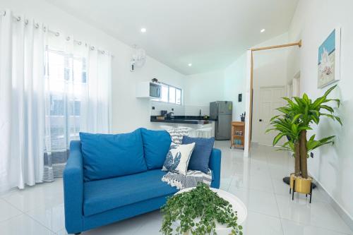 a blue couch in a living room with a kitchen at Apartamentos Cristal in Quepos