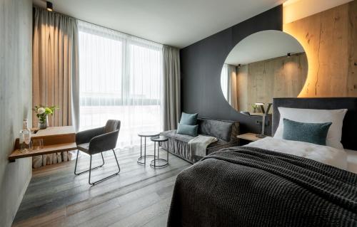 a bedroom with a bed and a mirror and a chair at WITTMANNs in Neumarkt in der Oberpfalz