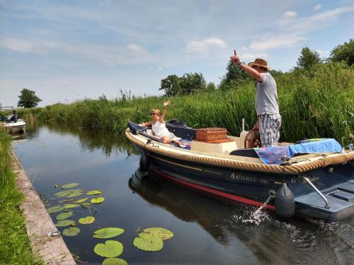 two men on a boat in the water at Het Waterhoentje in Sint Jansklooster