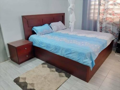 1 dormitorio con 1 cama con edredón azul en Villa pour vos vacances à Lomé, en Agouévé