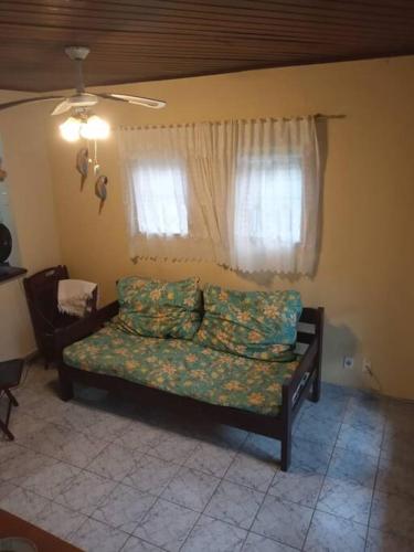 a bedroom with a couch in a room with a window at Apê aconchegante - 6 pessoas in Bertioga