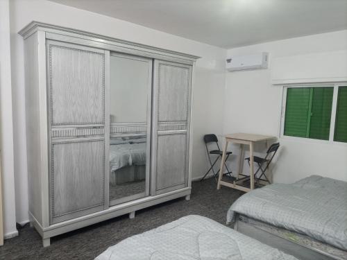 ein Schlafzimmer mit einem großen Kleiderschrank, einem Bett und einem Schreibtisch in der Unterkunft شقق مدن الديكابوليس in Irbid