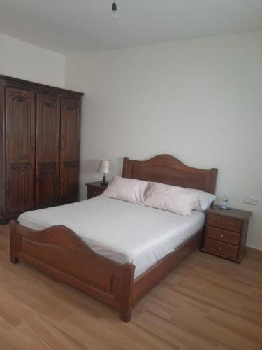 ein Schlafzimmer mit einem Holzbett und einer Holzkommode in der Unterkunft New Rif Appartement Appelle moi 07 et 74 et 41 et 16 et 91 in Al Hoceïma