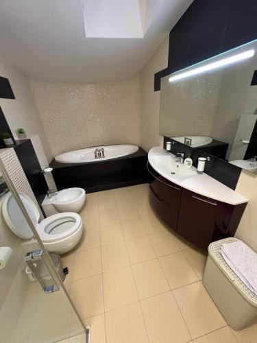 ein Badezimmer mit einer Badewanne, einem WC und einem Waschbecken in der Unterkunft Apartment on Arkhipenka with Panorama View in Lwiw
