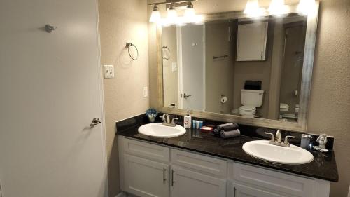 a bathroom with two sinks and a large mirror at Med Center Charm 2br Haven in Houston