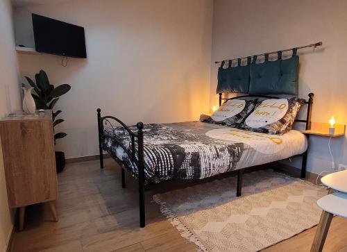 a bedroom with a bed with a headboard and a television at LA BRIE COSY in Quincy-Voisins