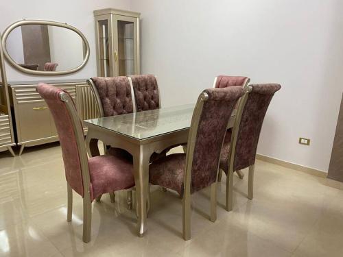 einen Esstisch mit Stühlen und einem Spiegel in der Unterkunft Furnished Apartment in Cairo, شقة مفروشة بجانب مطار القاهرة in Kairo