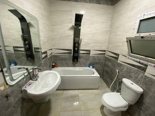 uma casa de banho com um WC, uma banheira e um lavatório. em Furnished Apartment in Cairo, شقة مفروشة بجانب مطار القاهرة no Cairo